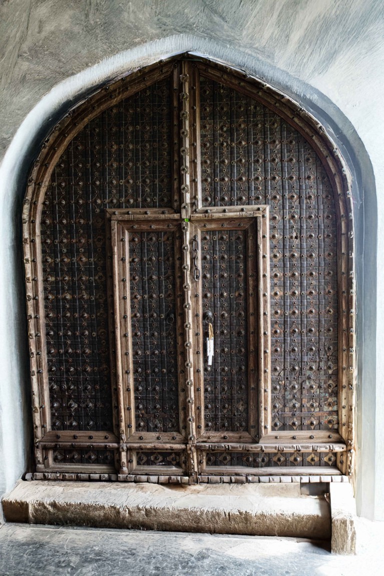 Grand Arched Wooden Door with Hand-Forged Ironwork